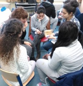 Schüler sitzen im Stuhlkreis und lesen