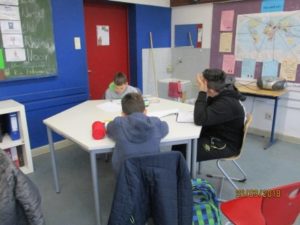 drei Schüler lesen am Gruppentisch