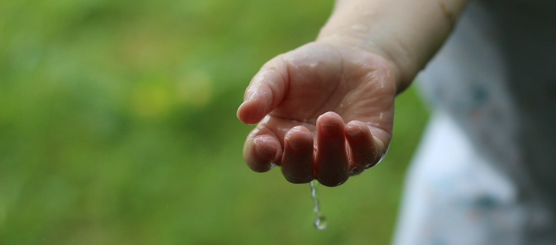 Kinderhand nass vom Regen