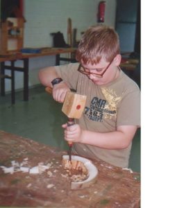 Schüler mit Hammer und Meißel