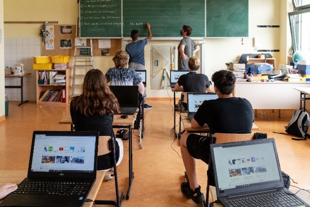 Schüler*innen mit Laptops im Klassenzimmer