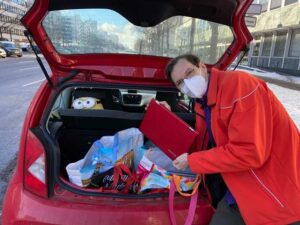 Mann vor eoinem Auto mit Computer in der Hand