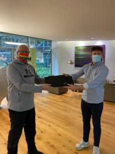 Zwei Männer halten einen Laptop zwischen sich