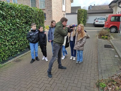 Ein Kameramann filmt Schülerinnen und Schüler des Gymnasiums