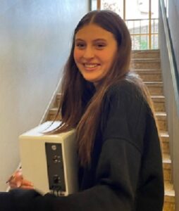 Ein Elektrogerät wird zur Sammeltonne getragen